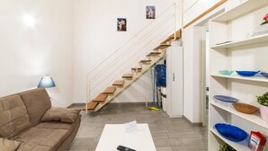 A modern living room with a staircase, a sofa, and a coffee table. - Vico Santo Spirito di Palazzo 34 (Naples)