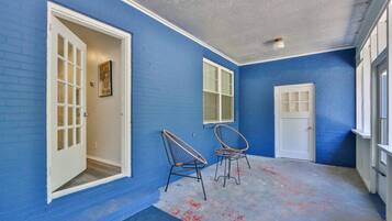 A room with blue walls, a white door, and two wicker chairs.