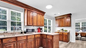 Una cocina con armarios de madera, microondas y cafetera.