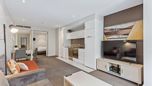 Et moderne hotelværelse med opholdsområde, tekøkken og et separat soveværelse.