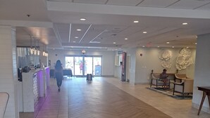 A spacious lobby with a herringbone floor pattern, a reception desk, and seating areas. - Beautiful 1 bedroom condo on the beach in Pompano Beach (Pompano Beach)