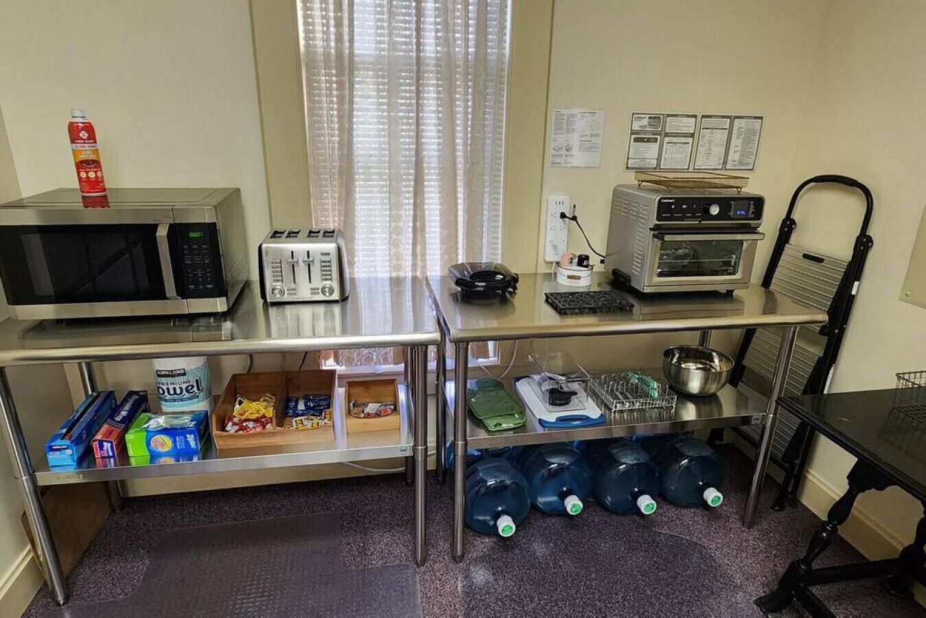 Une petite cuisine équipée d’un four à micro-ondes, d’un grille-pain et d’un four. On y trouve des étagères pour ranger les aliments et un évier avec un robinet.