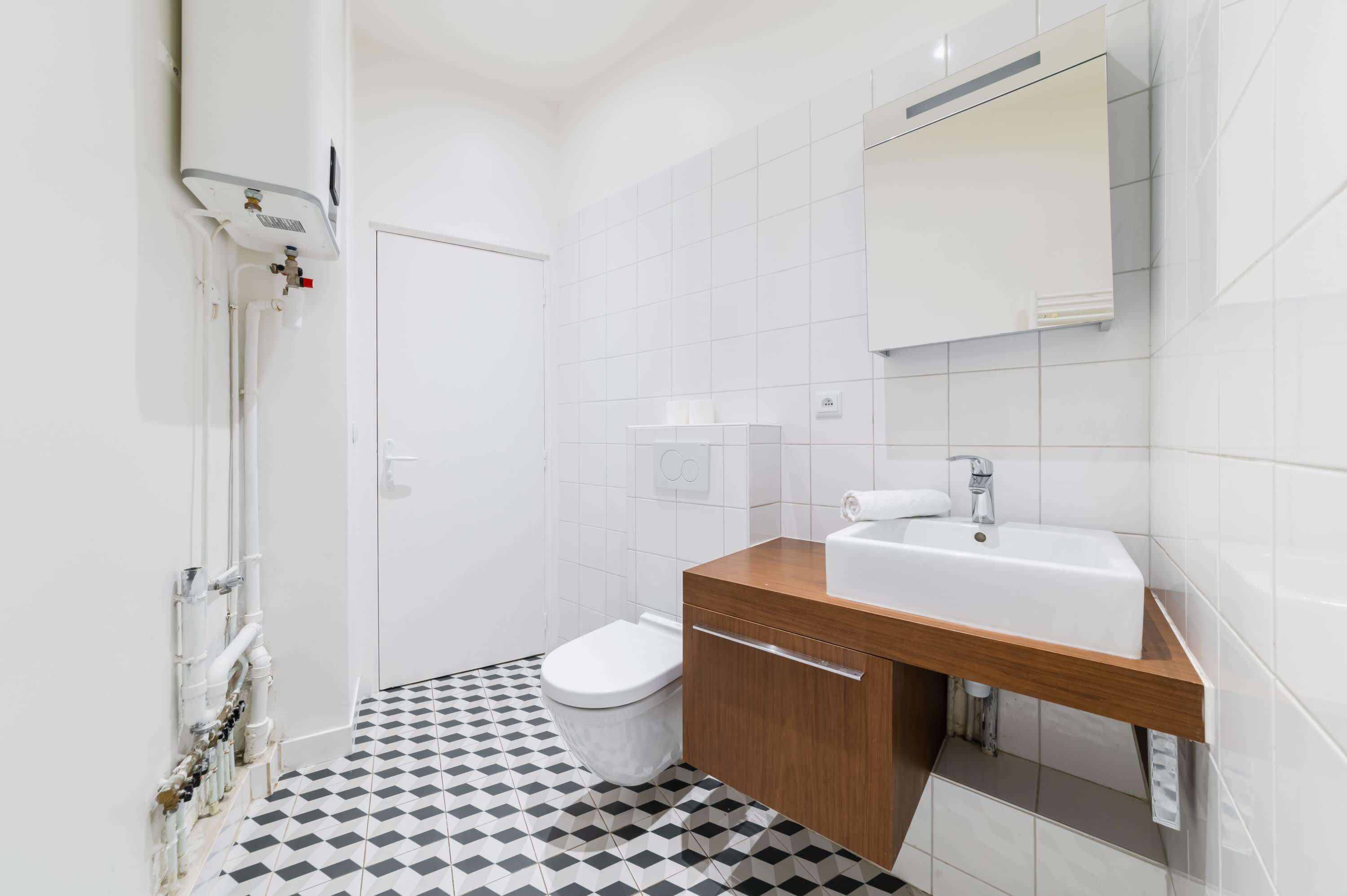 A modern bathroom with a toilet, sink, and shower.