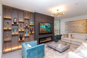A modern living room with a fireplace, a television, and a sofa.