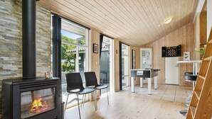 A modern living room with a wood-burning stove, two black chairs, a foosball table, and a dartboard. - "Edin" - 150m from the sea by Interhome (Aabenraa)