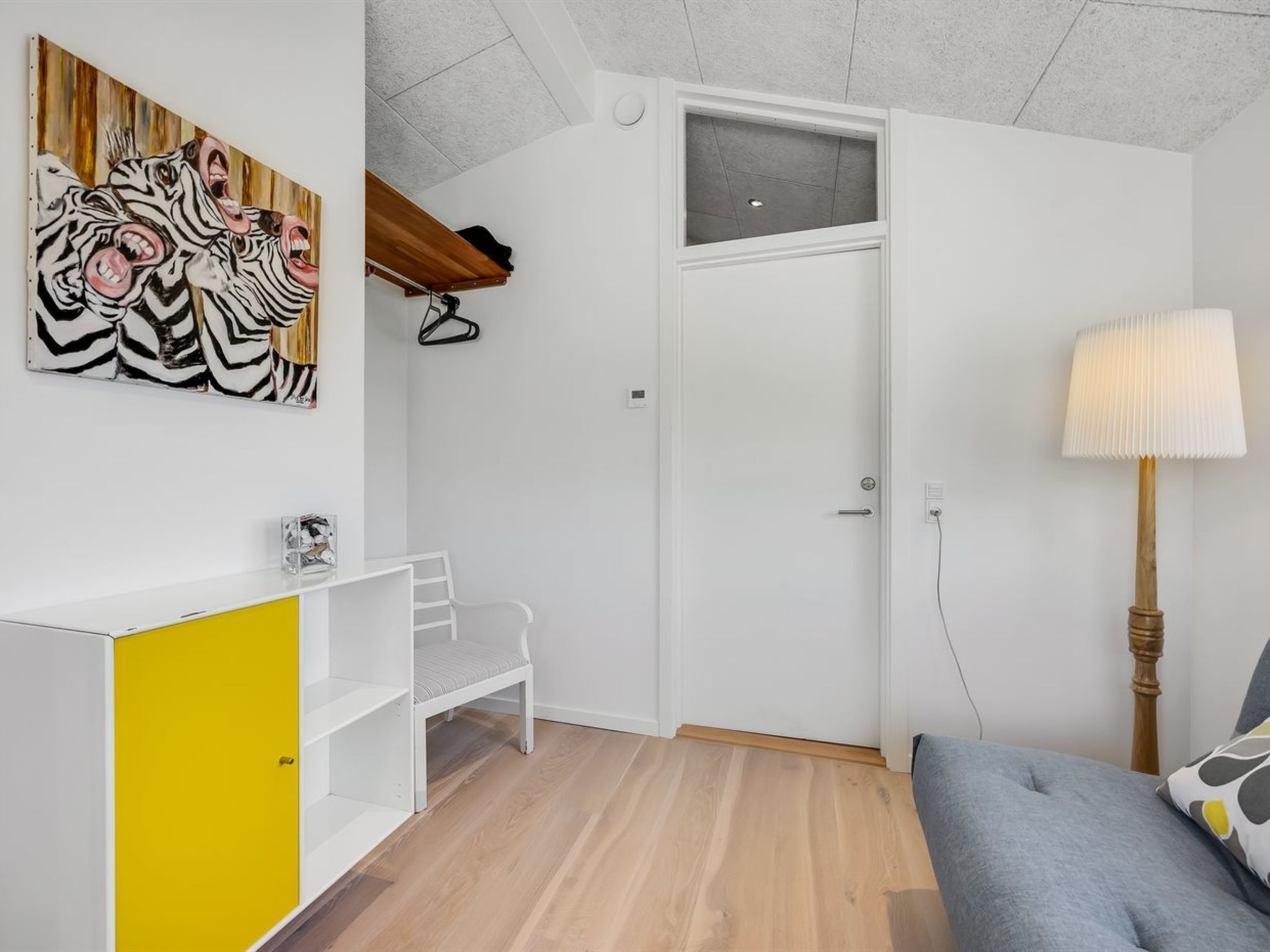 A compact room with a bed, a desk, and a wardrobe.