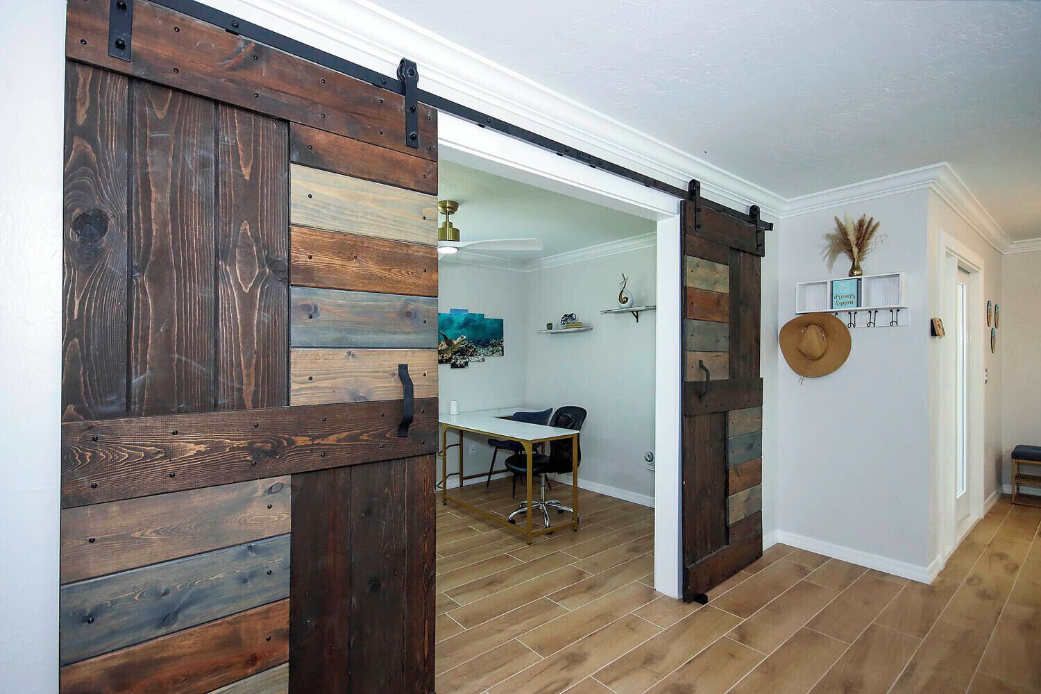 Een kamer met een houten schuifdeur, een bureau en een stoel.