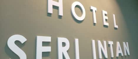Una pared con las palabras 'HOTEL SERI INTAN' en letras grandes y blancas.