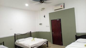 Una habitación con dos camas, ventilador de techo, aire acondicionado y una puerta.