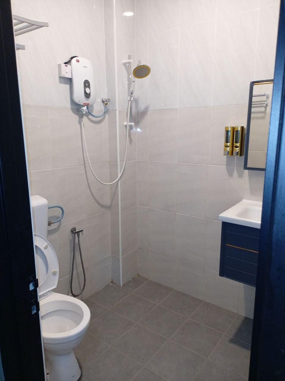 A bathroom with a toilet, a shower, and a sink.