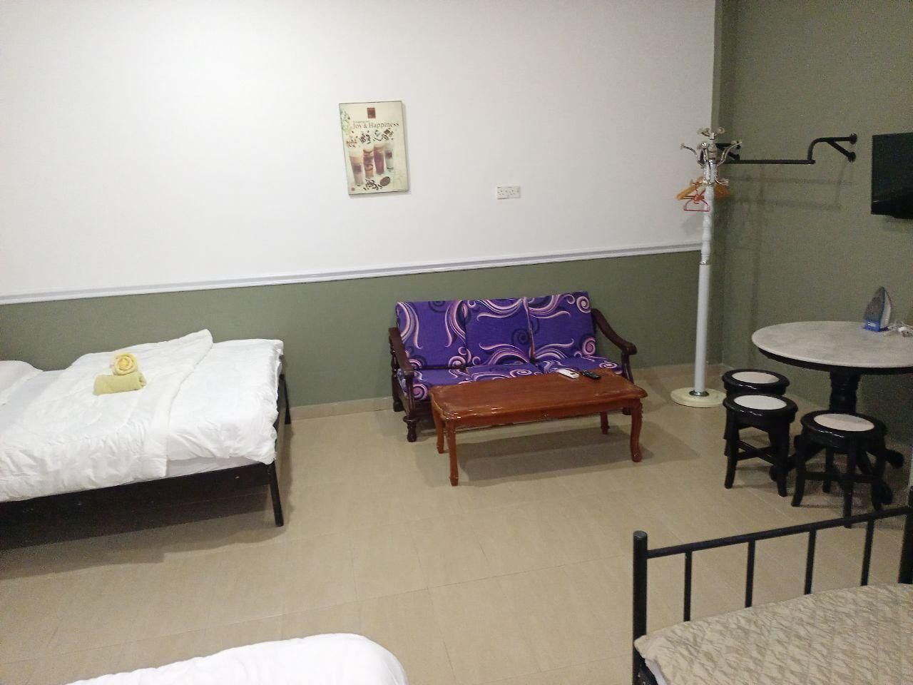 Una habitación con cama, sofá, una mesita y una silla.