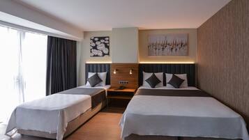 Habitación de hotel con dos camas, una mesita de noche y un teléfono en la pared.