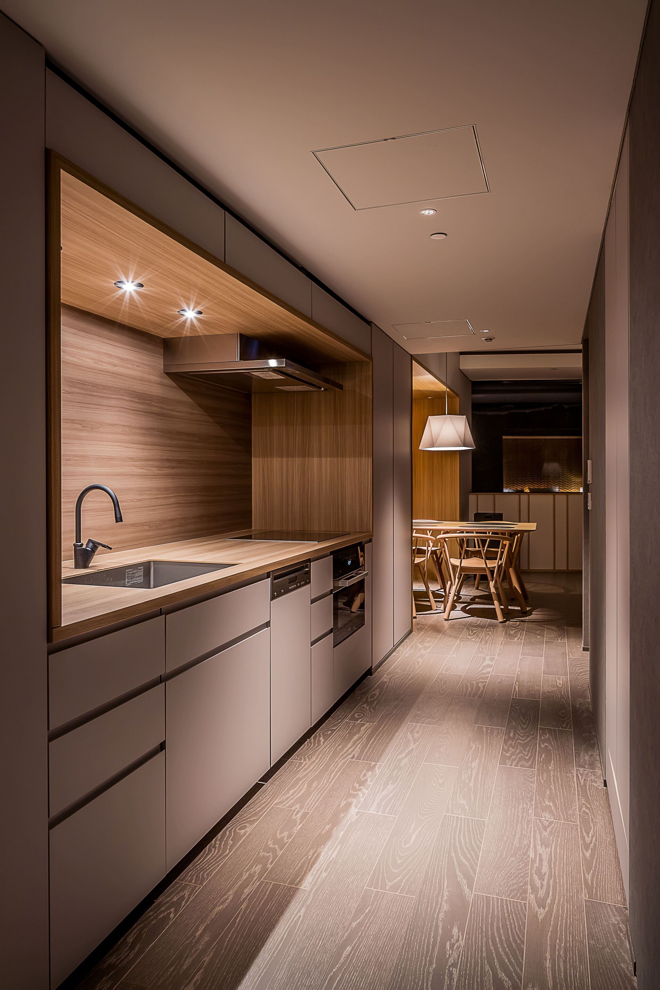 A modern kitchen with a wooden countertop, built-in appliances, and a dining area with a table and chairs.