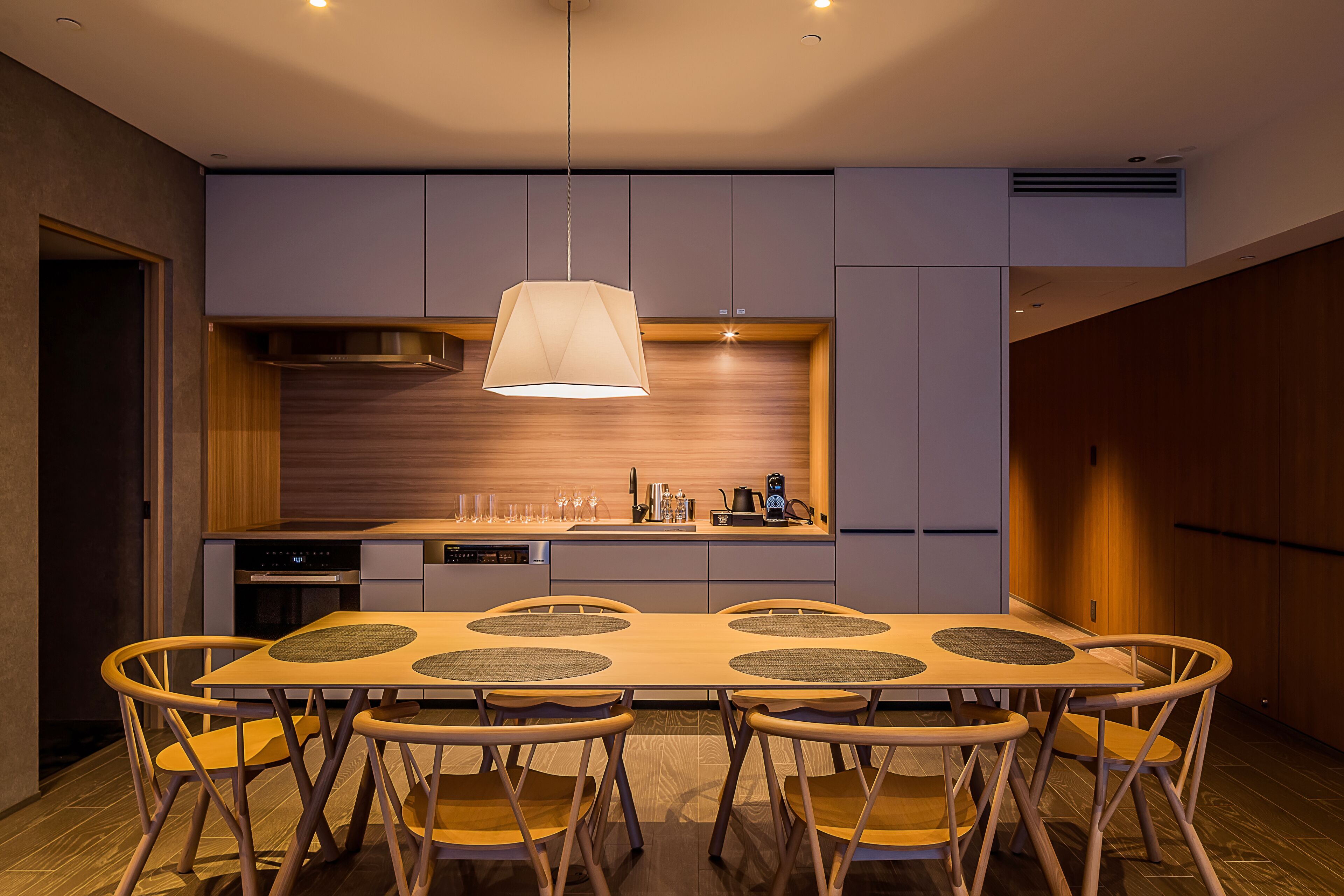 A modern kitchen with a central island, built-in appliances, and a pendant light.