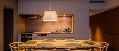 A modern kitchen with a central island, built-in appliances, and a pendant light.