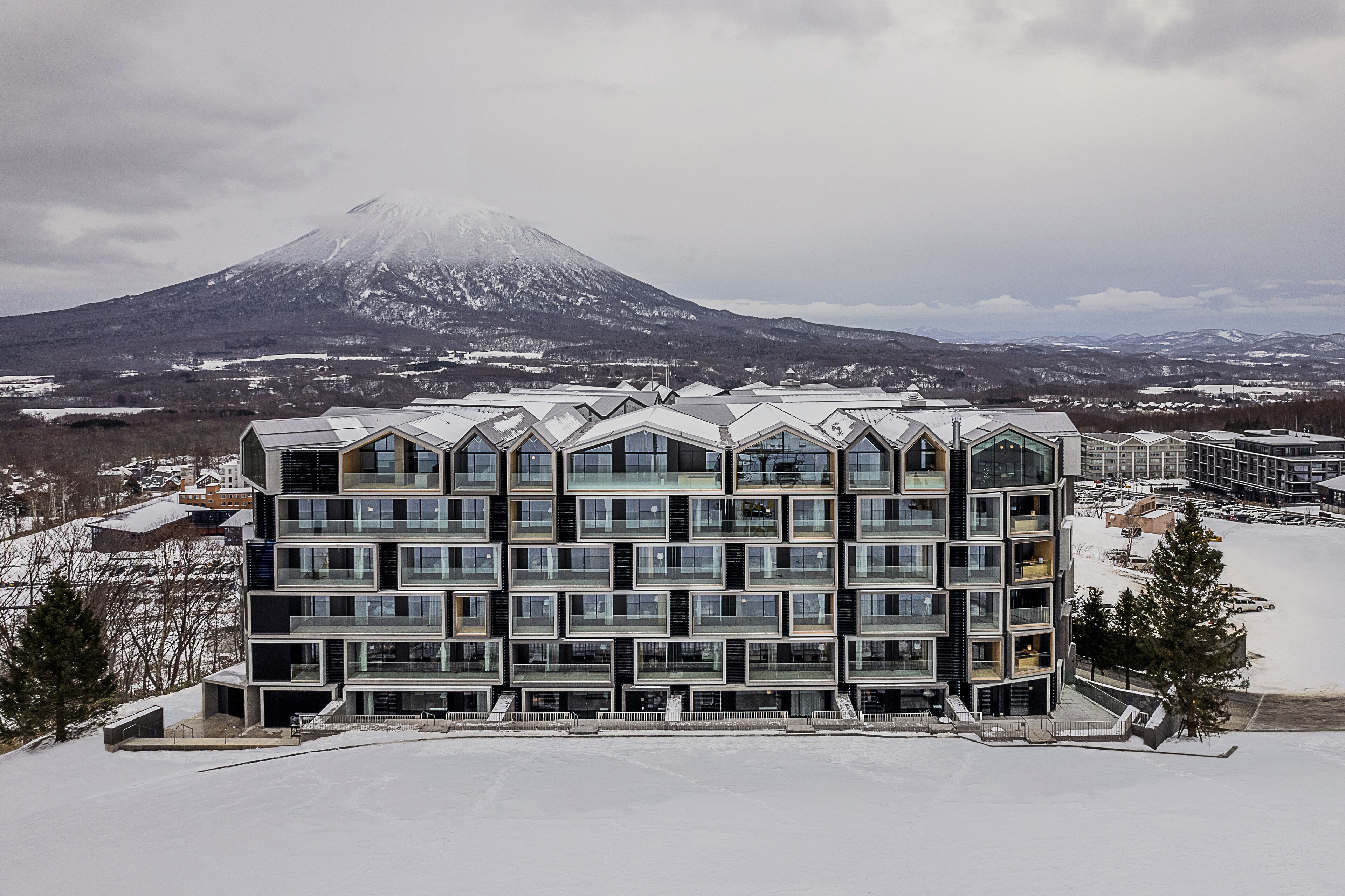 A modern multi-story hotel with a symmetrical facade, large windows, and a flat roof.