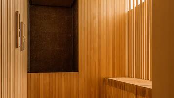 A sauna with wooden walls and benches, a clock, and a ventilation system.