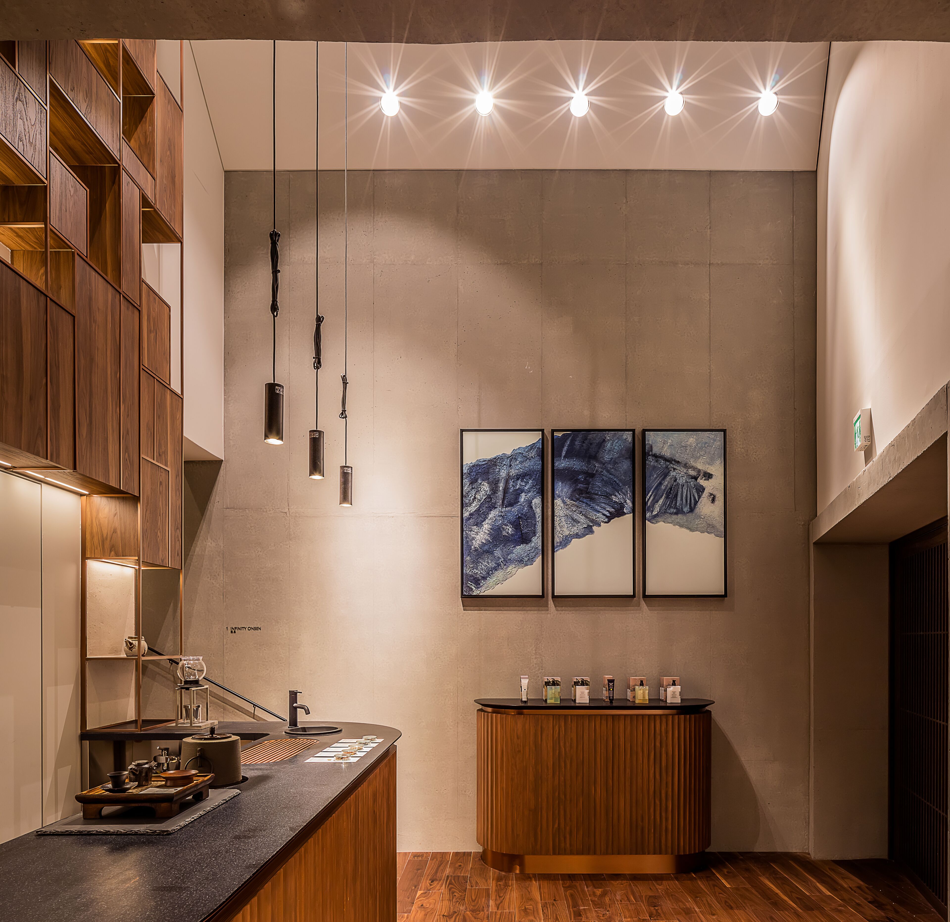 A modern kitchen with wooden cabinetry, pendant lighting, and a central island with a sink.
