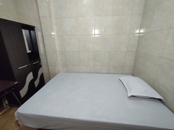 A small, clean room with a single bed, a desk, and a chair. - Homestay Kingkost at Nanda (Ngaglik)