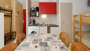 A compact kitchen with a microwave, coffee maker, and a washing machine. - Apartment 'Le Relais Du Devoluy' with Mountain View and Terrace (Le Dévoluy)