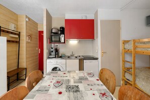 Cuina compacta amb microones, cafetera i rentadora.