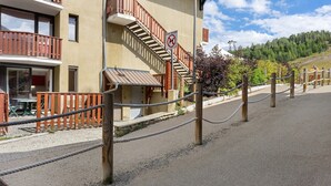 A building with a wooden balcony, a staircase, and a no dogs sign. - Apartment 'Le Relais Du Devoluy' with Mountain View and Terrace (Le Dévoluy)