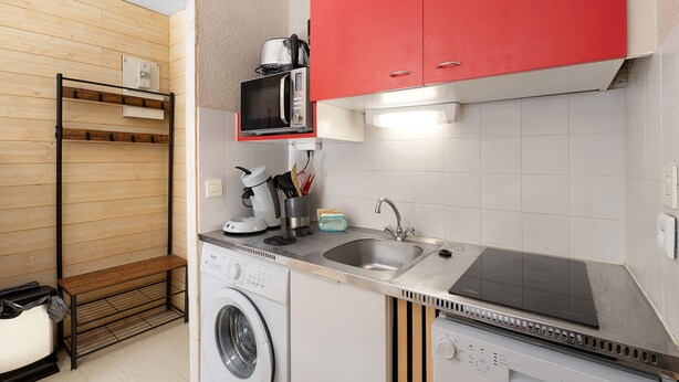 A compact kitchenette with a microwave, coffee maker, and a washing machine. - Apartment 'Le Relais Du Devoluy' with Mountain View and Terrace (Le Dévoluy)