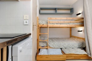 A bunk bed with a wooden frame, a washing machine, and a shelf above the bed. - Apartment 'Le Relais Du Devoluy' with Mountain View and Terrace (Le Dévoluy)