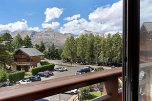 Vista de la montaña con estacionamiento, un edificio de madera y cielo despejado.