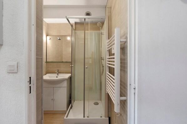 A bathroom with a glass-enclosed shower, a sink, and a towel rack. - Studio "Les Fontettes 2" 50 meters from ski slopes with balcony (Le Dévoluy)