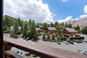 A mountain lodge with multiple wooden cabins, a parking lot, and a view of the surrounding forest and mountains. - Studio Apartment "Les Fontettes 2" near Slopes with Balcony & Shared Pool (Le Dévoluy)