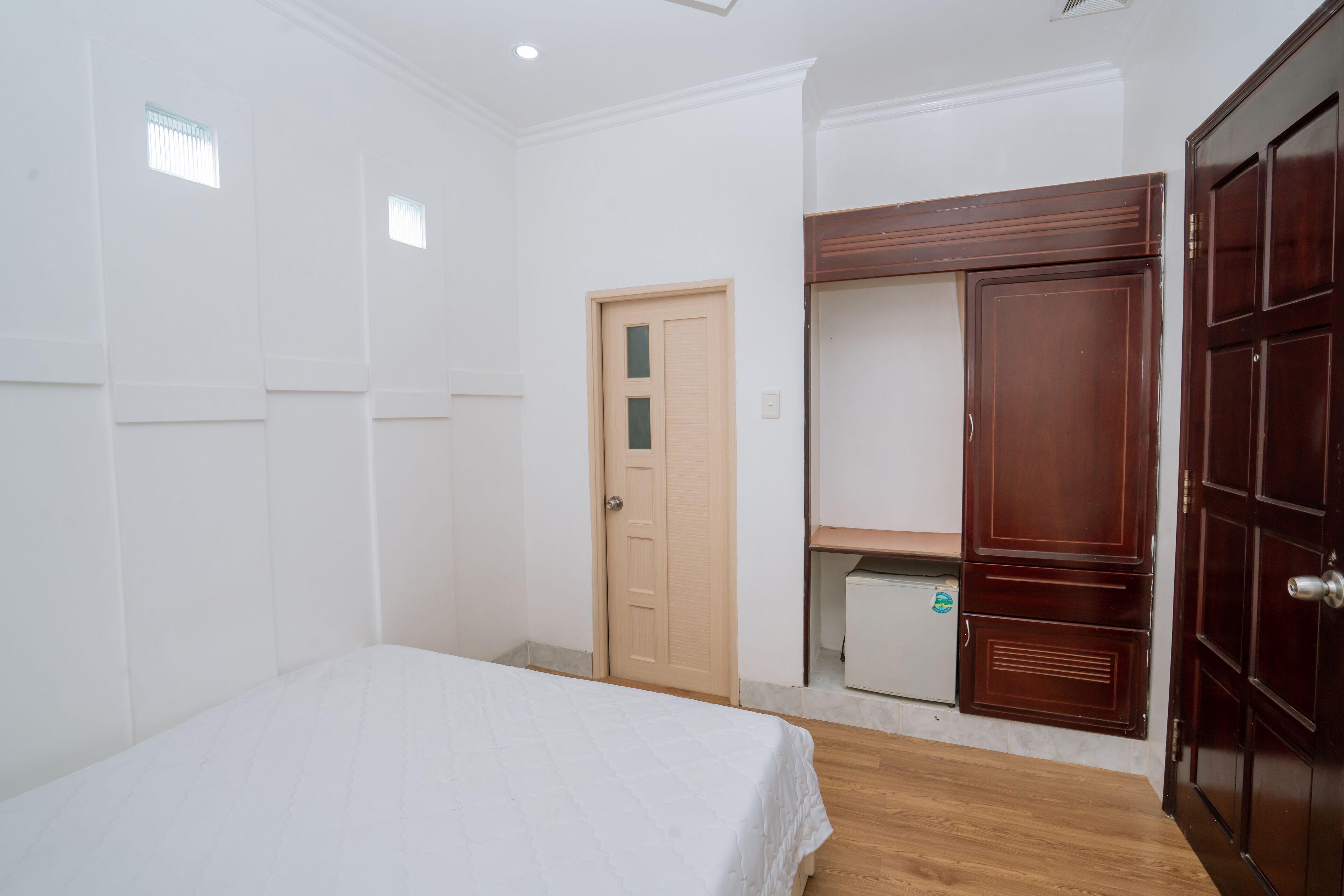 Et soveværelse med seng, garderobe og dør.