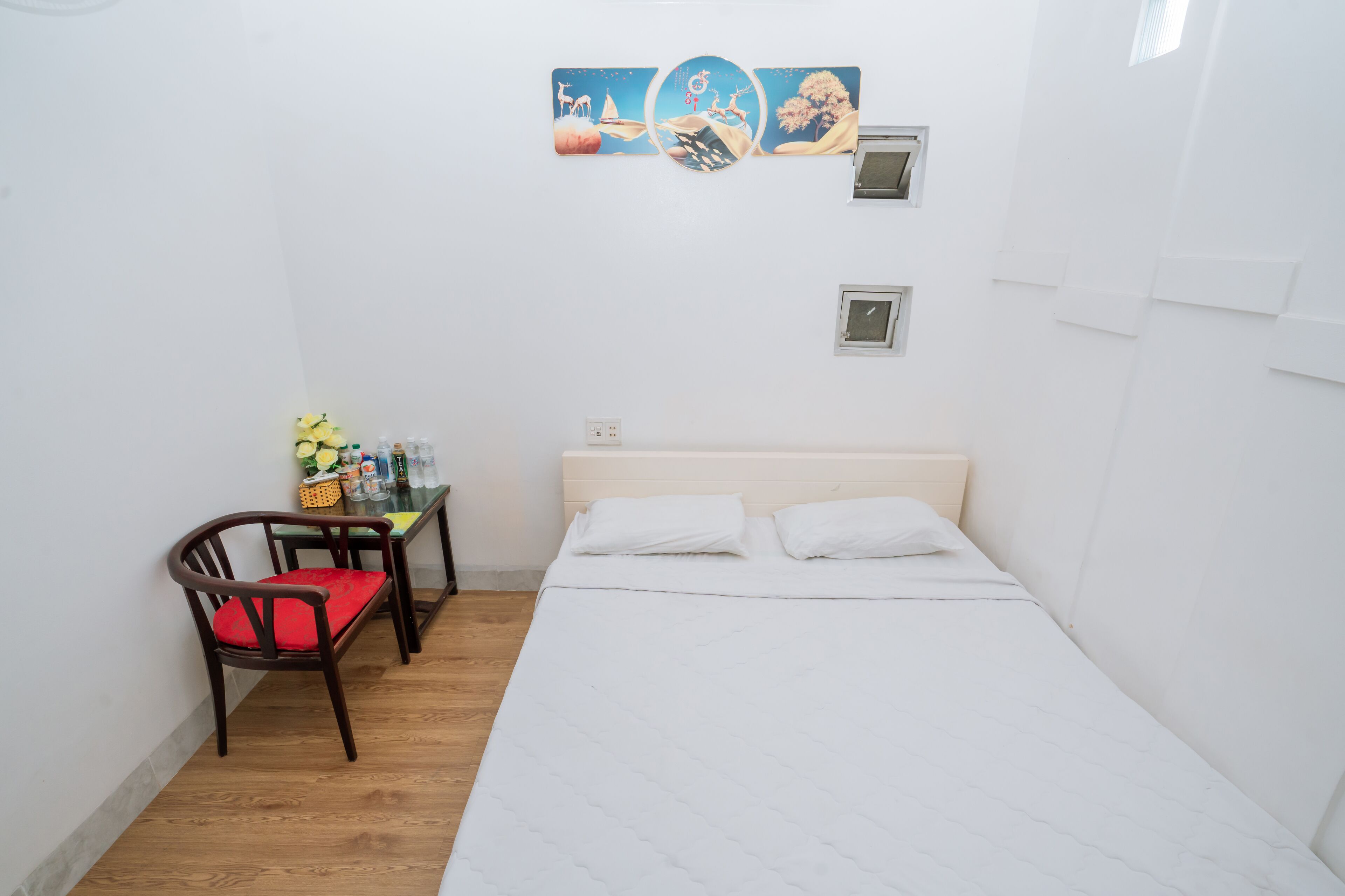 Una habitación pequeña y limpia con una cama, un escritorio con silla y una estantería con artículos de aseo.