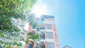 A multi-story building with a staircase leading to the entrance. - Trieu Vu Hotel & Apartment (Buon Ma Thuot)