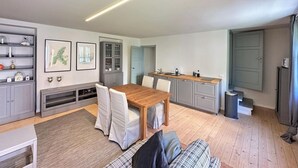 Un espace de vie compact comprenant un coin repas, une kitchenette et un canapé.