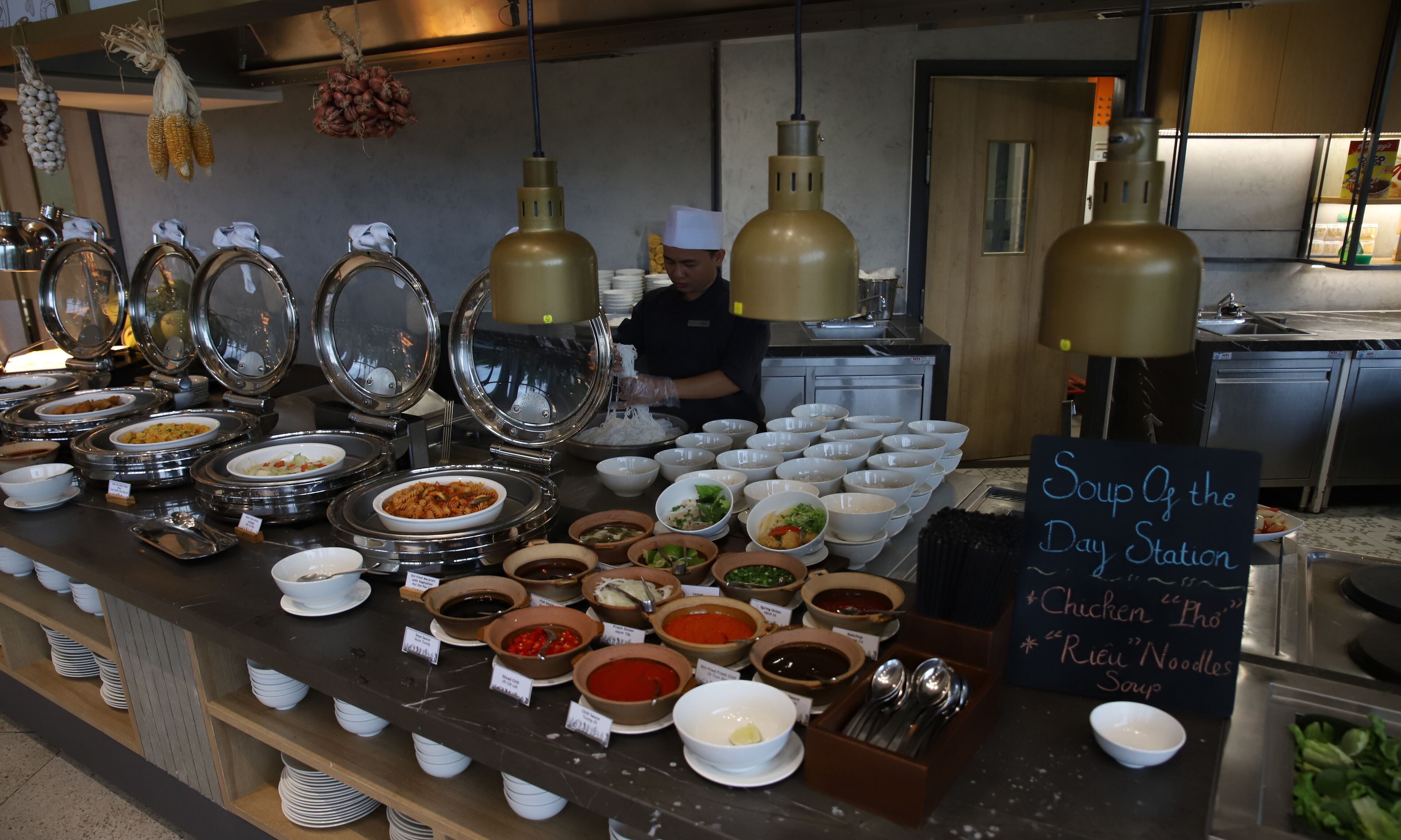 A buffet with various dishes and a sign indicating 'Soup of the Day Station'.