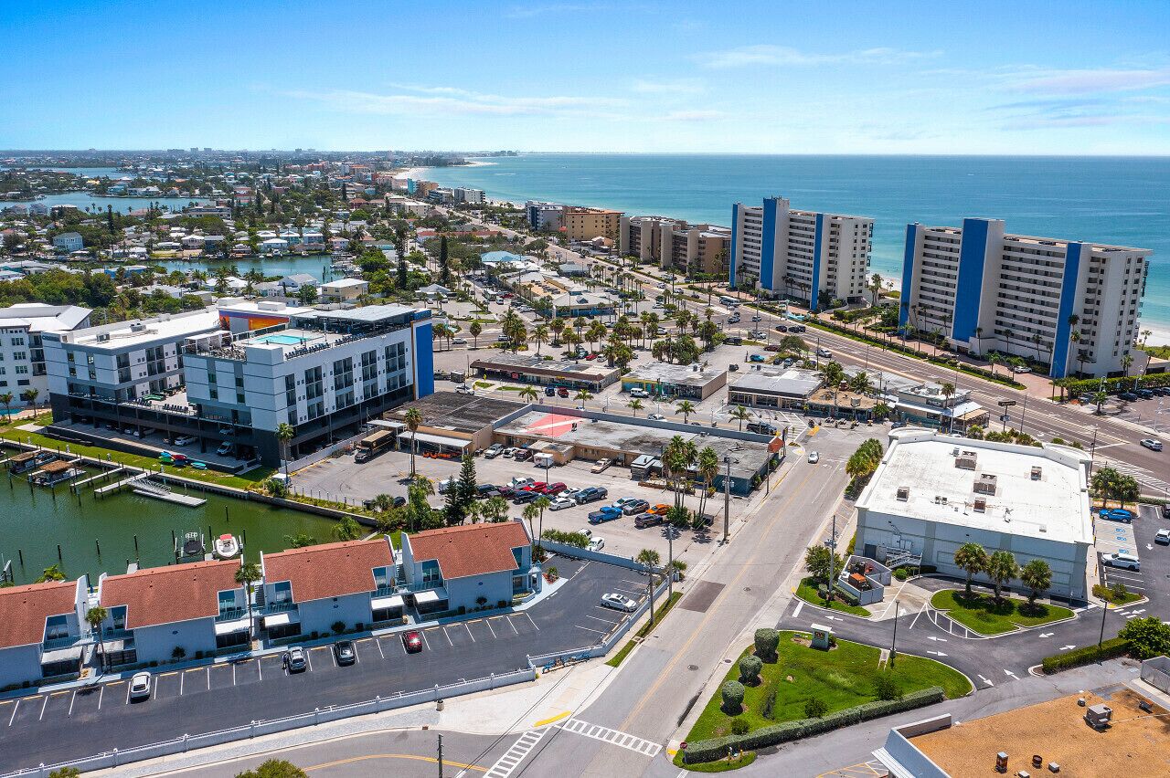 Un paysage urbain côtier avec un port de plaisance, des immeubles de grande hauteur et une vue dégagée sur l’océan.