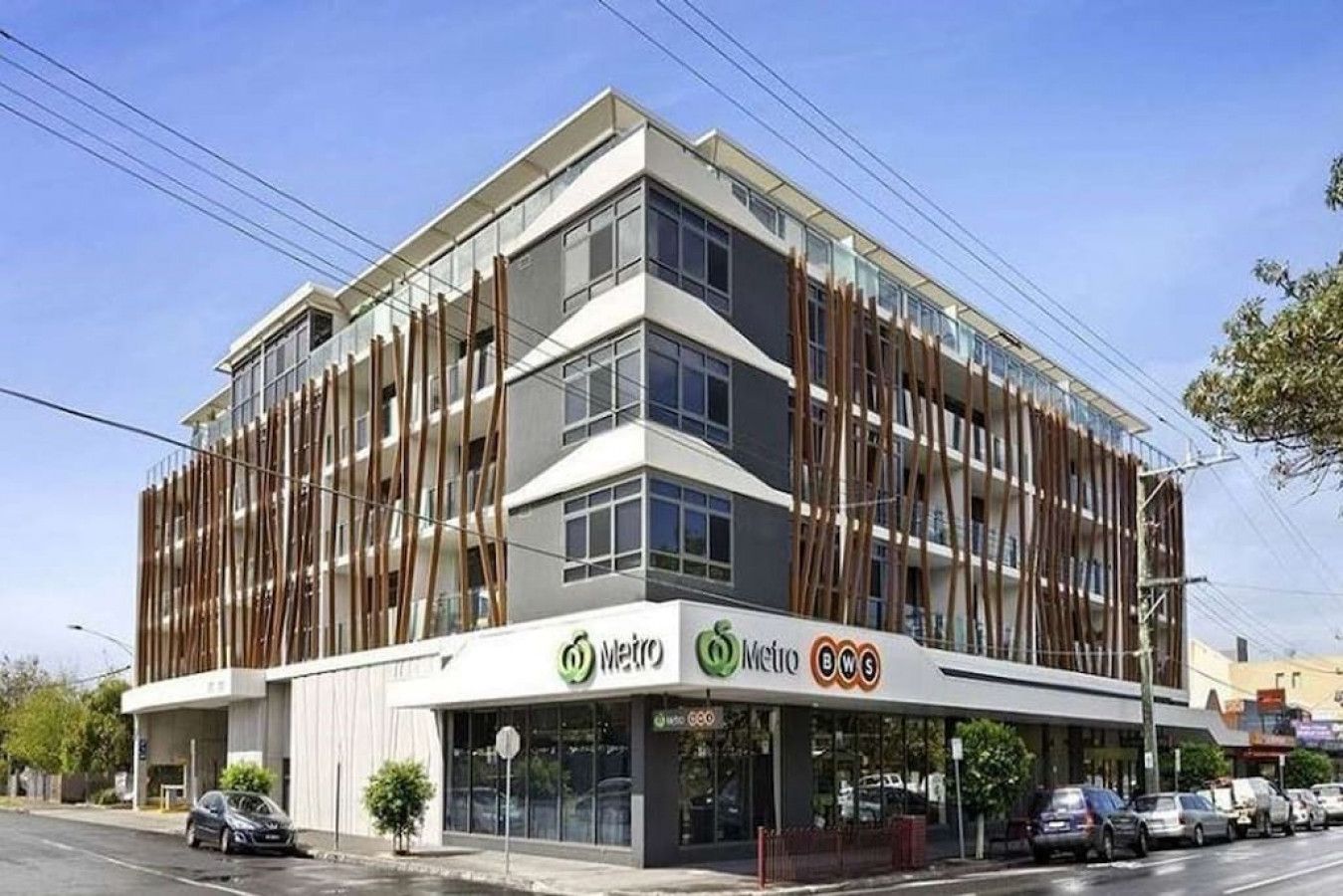 A modern building with a Metro BWS sign, featuring a multi-story structure with large windows and a flat roof.