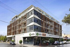 Un edificio moderno con el letrero Metro BWS, que presenta una estructura de varios pisos con amplias ventanas y techo plano.