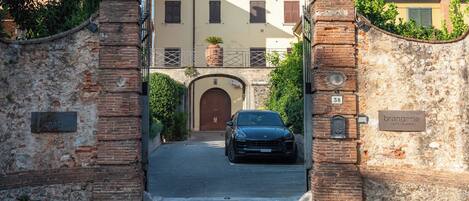 A gated entrance to a building with a parked car, a sign reading "Paradisi", and a sign for "Brangerie".