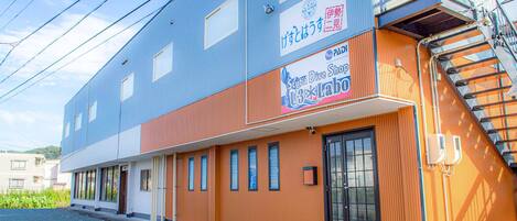 A building with a blue and orange facade, a visible entrance, and a sign for a scuba dive shop.