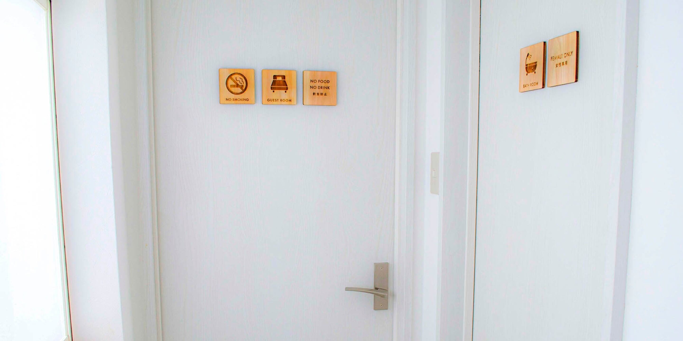 A white door with three signs: "NO SMOKING," "GUEST ROOM," and "NO FOOD NO DRINK."
