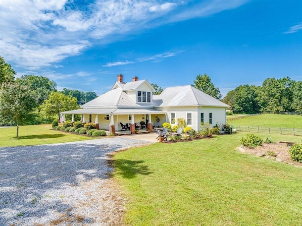 Une maison de plain-pied avec un porche, une allée et une pelouse bien entretenue.