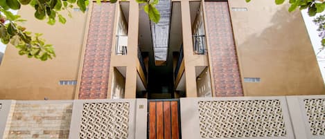 A modern building with a central entrance, two balconies, and a number '88' on the wall.