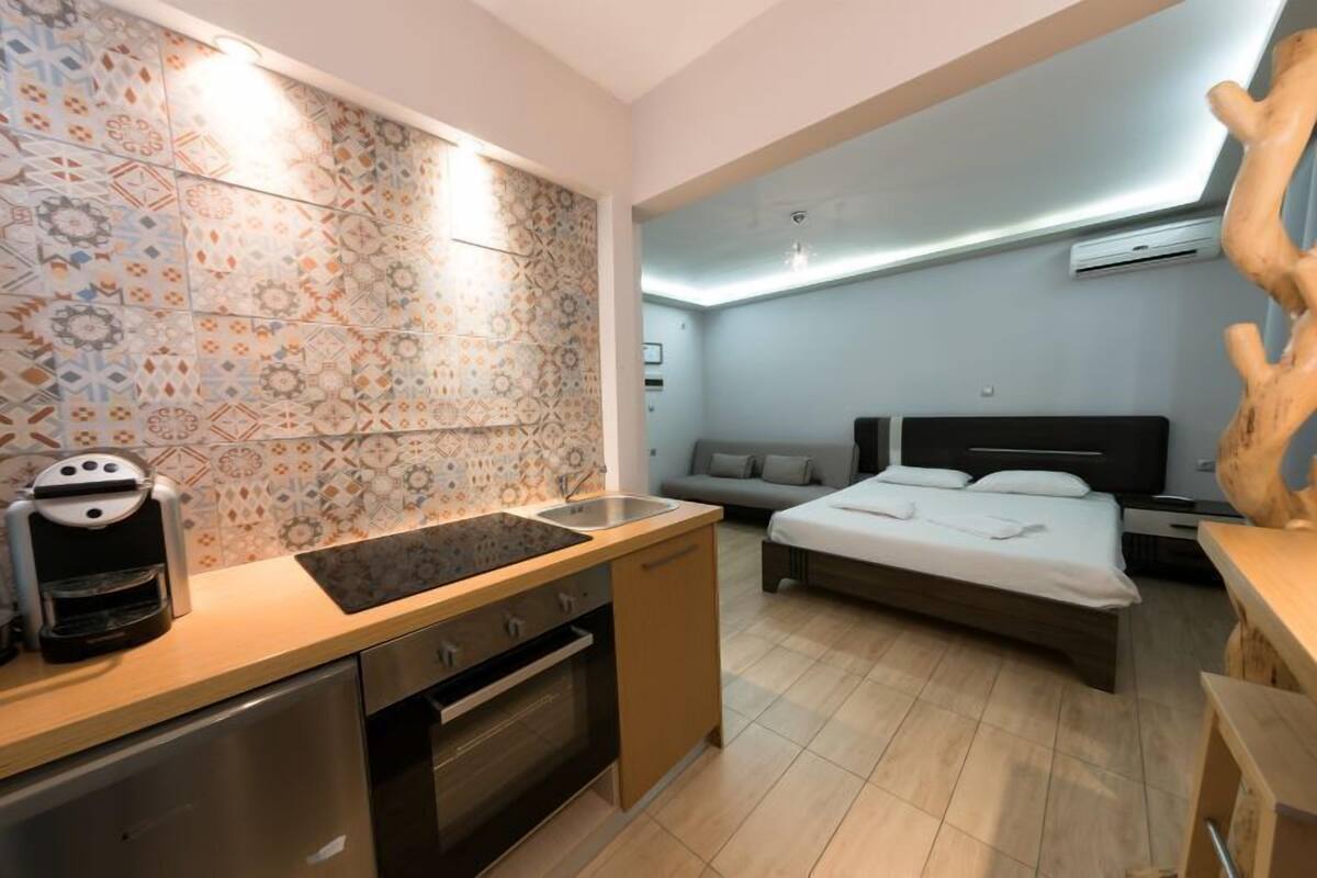 Moderni hotellihuone, jossa on keittotila, sänky ja suuri puuveistos.