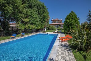 A rectangular swimming pool with clear blue water, surrounded by lounge chairs and a tiled deck. - Private villa w/ large pool, walking distance from beach, near Athens (Ag. Panteleimon)