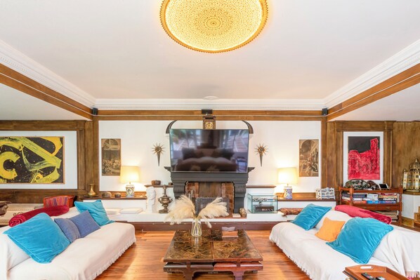 A spacious living room with a fireplace, two sofas, a coffee table, and a television. - Riad Riari (Roma)