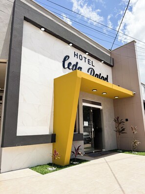 A hotel entrance with a modern design, featuring a yellow overhang and a sign that reads "HOTEL Ceda Point." - Pousada Leda Rafael (Joao Camara)