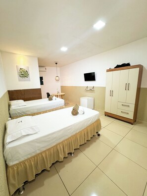 A hotel room with two single beds, a wardrobe, a television, and a ceiling light. - Pousada Leda Rafael (Joao Camara)