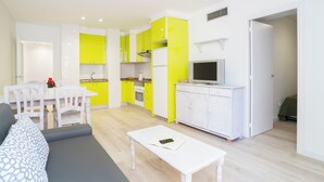 A compact living space with a dining area, kitchenette, and a seating area. - Apartamentos de 2 Dormitorios con Piscina en Pleno Centro de Salou! (Salou)